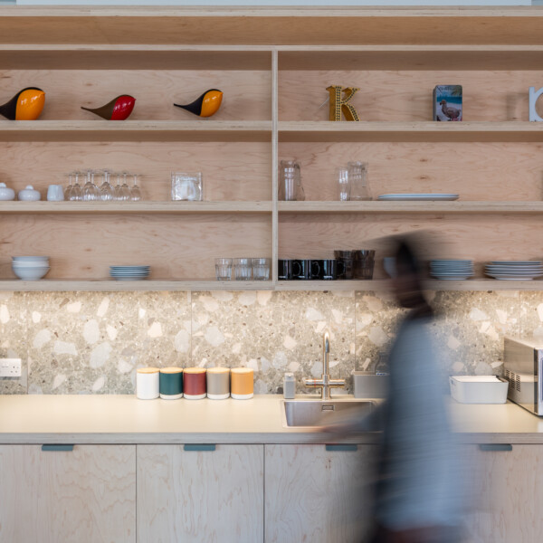 Kitchen shelving of Endpoint London studio, with person walking past