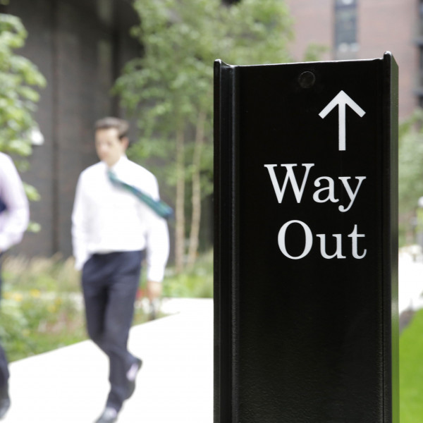 Workers walking past our distinctive wayfinding design at Embassy Gardens