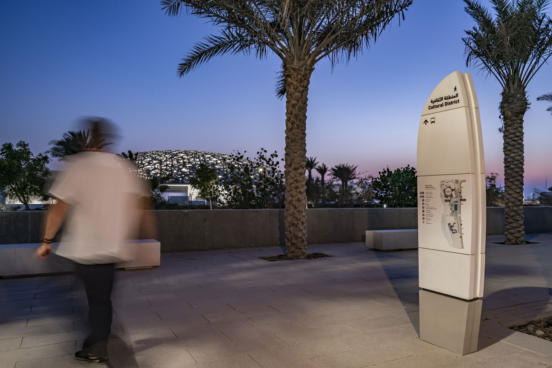 Masterplan wayfinding - Visitor walking by our sign at Saadiyat Island
